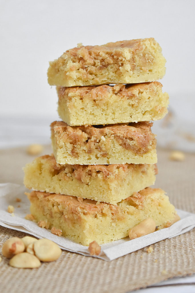 Low carb peanut butter swirl blondies with peanuts on a brown cloth stacked