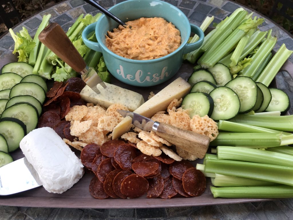 Low carb buffalo chicken dip with vegging as chips and cheese and cheese crisps.