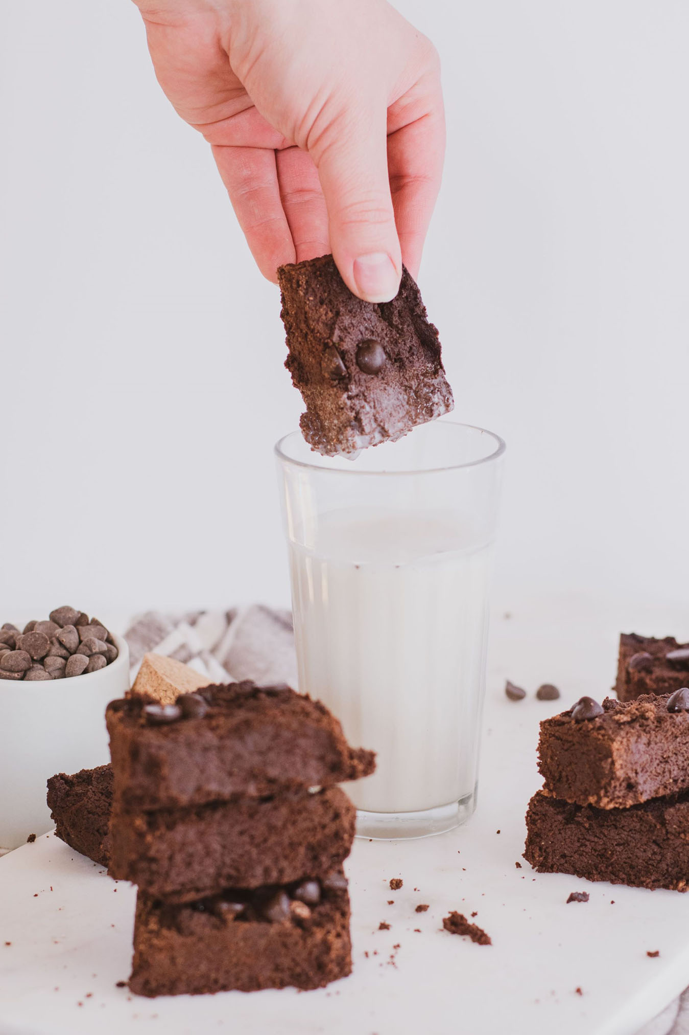 Keto Avocado Brownie being dipped in some Almond Milk