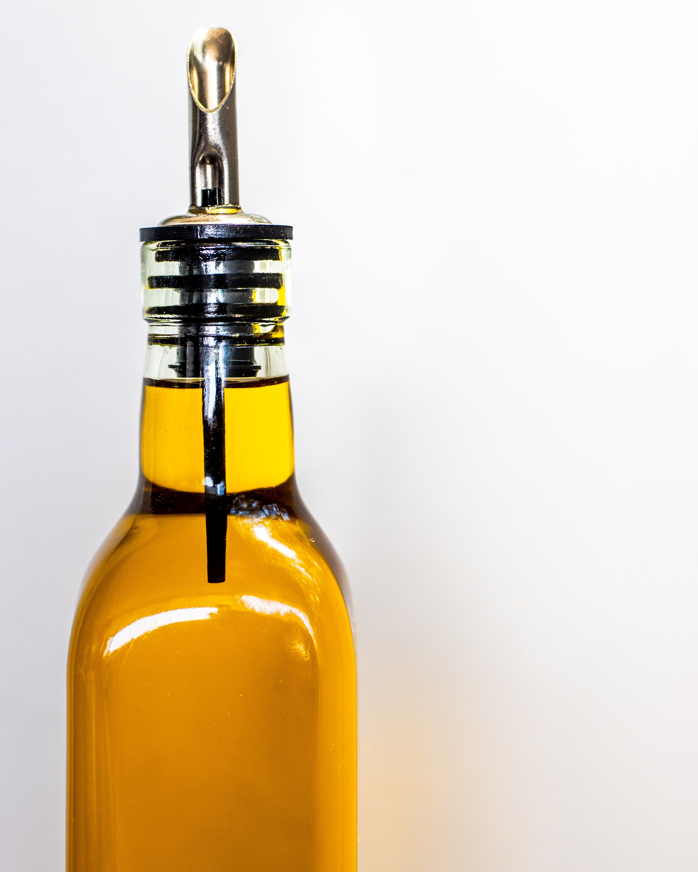 Olive Oil in a clear bottle with a white background