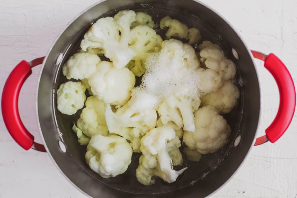 Low carb cauliflower in pot on a white surface.
