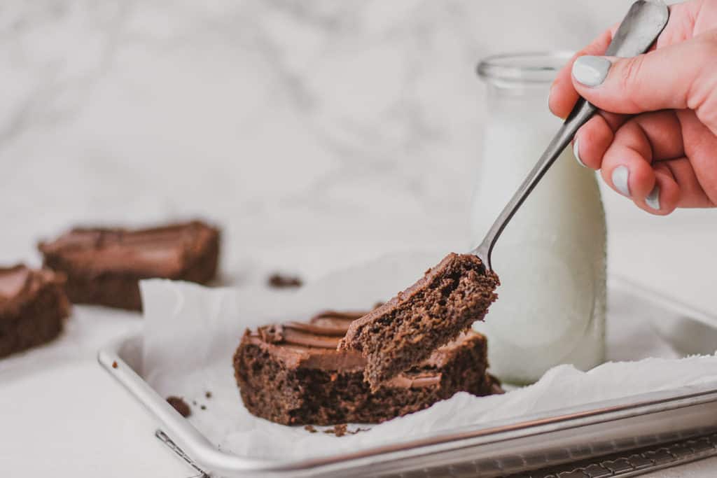 Keto chocolate sheet cake slice with a fork taking a bite.
