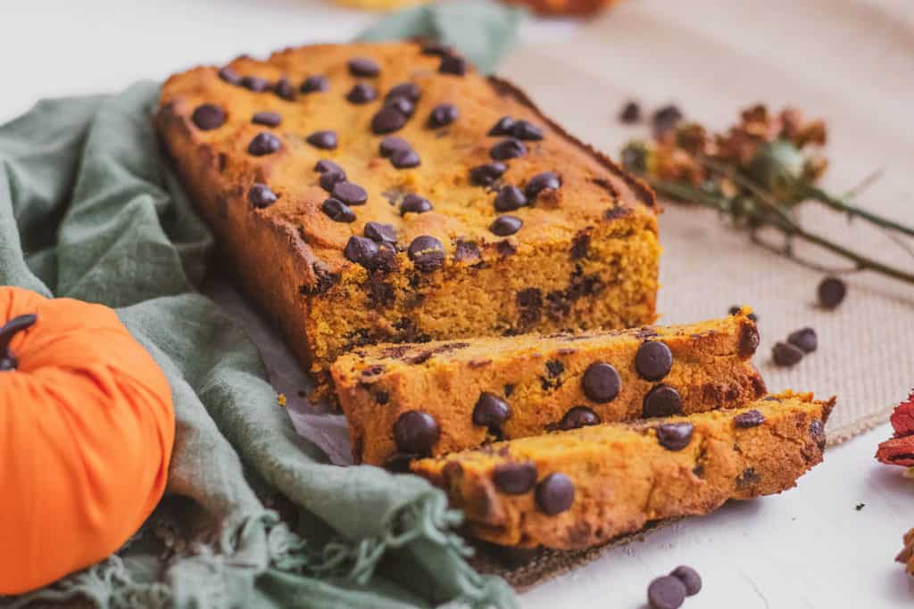 Keto Chocolate Chip Pumpkin Bread sliced loaf with a green napkin on the side. 