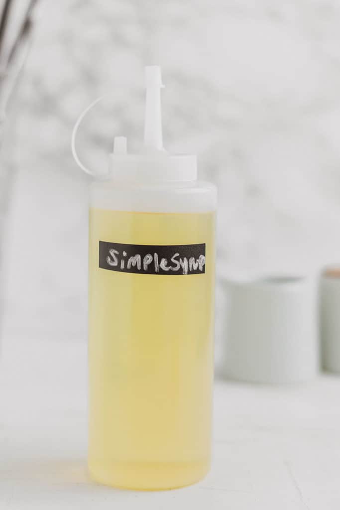 Keto Simple Syrup in a clear bottle on a white surface.