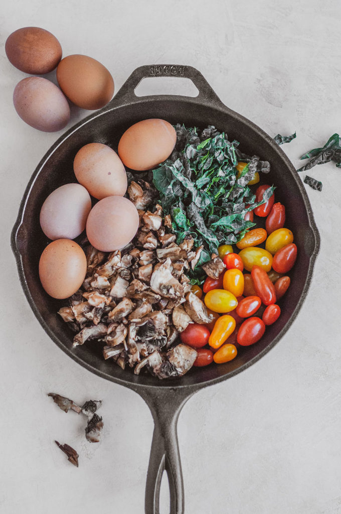 Keto Kale and Mushroom Frittata ingredients in a skillet