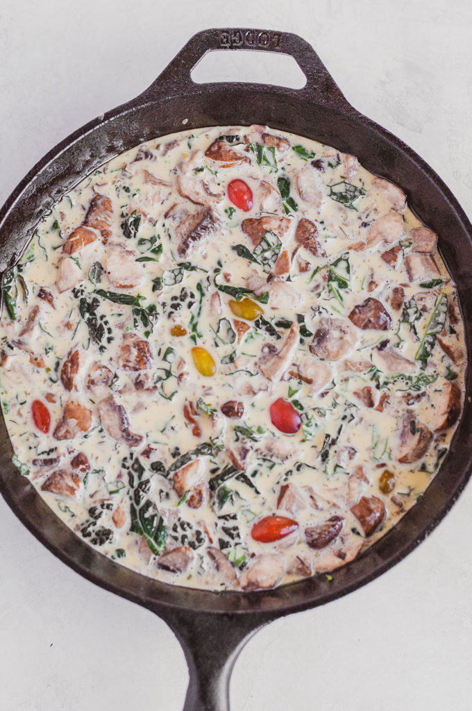 Keto Kale and Mushroom Frittata ingredients mixed up in a skillet